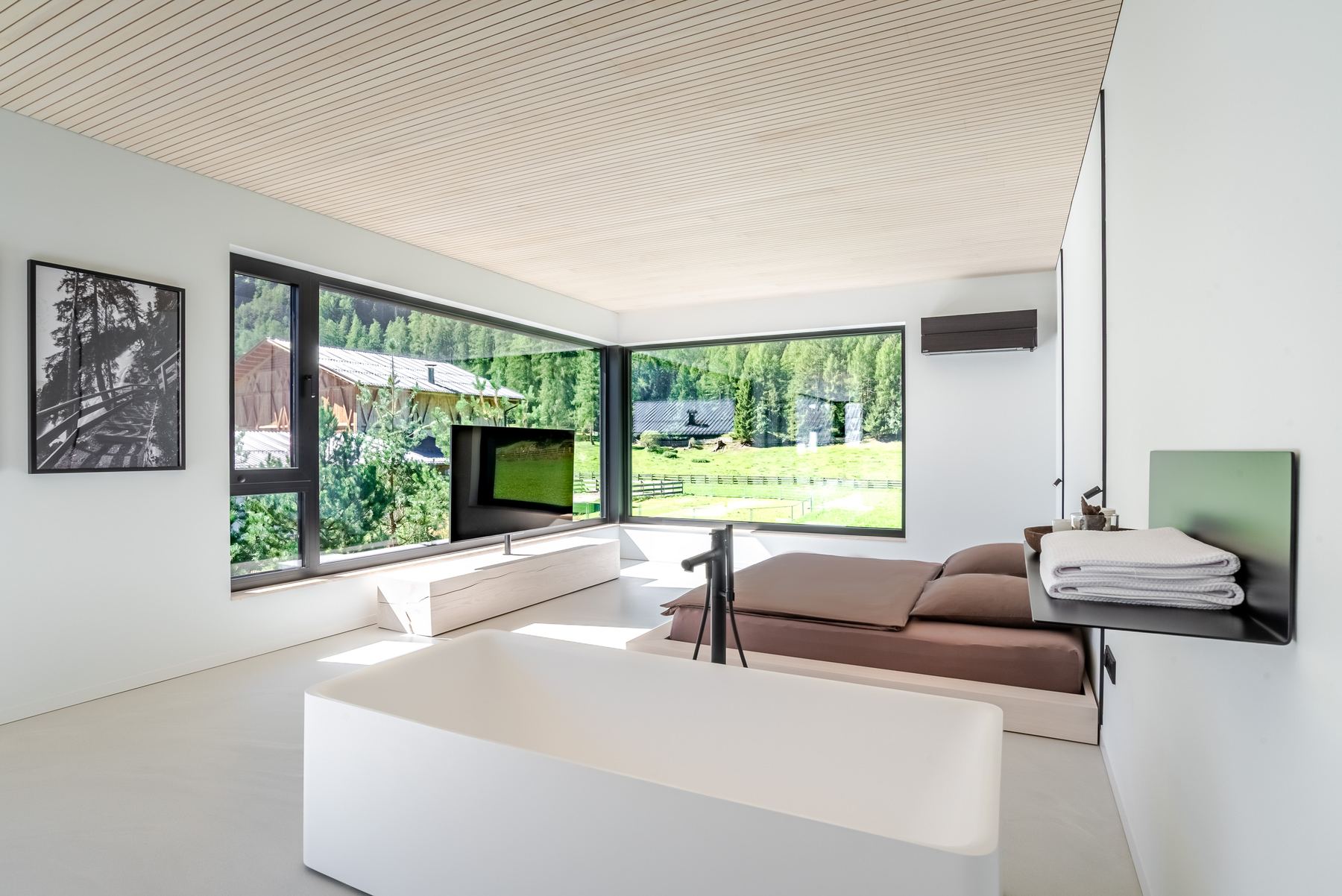 Wohnraum mit raumhohen Eckfenstern und Blick in den Garten